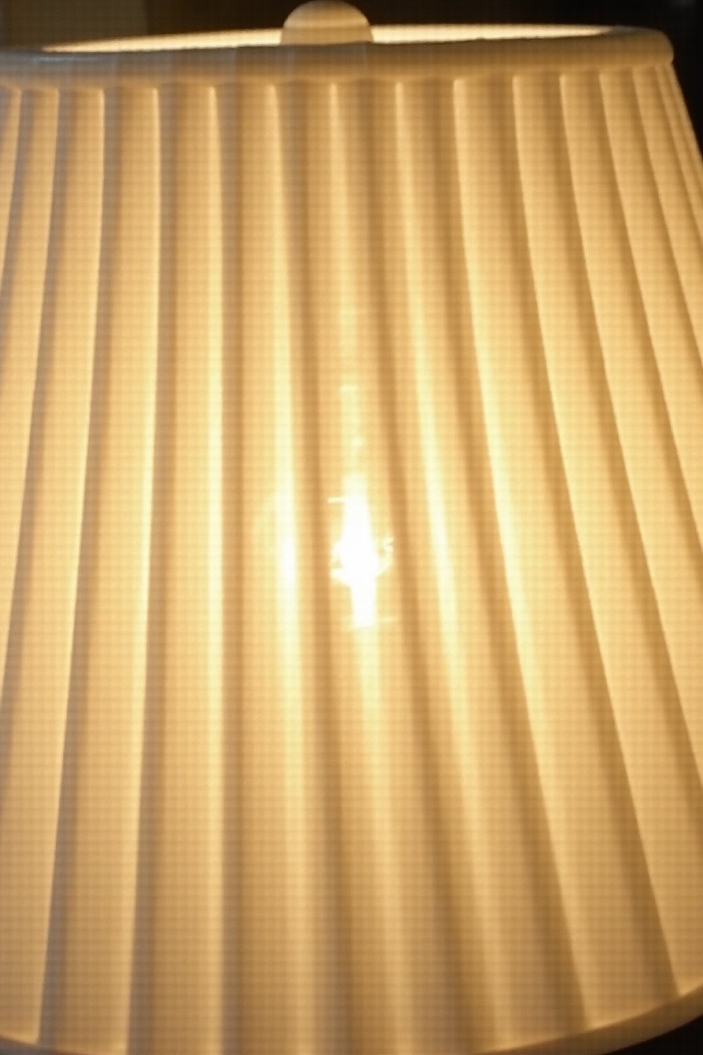 Close-up detail of a pleated linen lampshade showing the texture and folds of the fabric