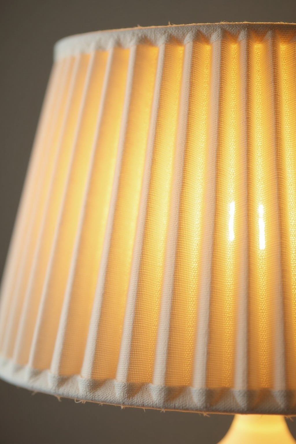 Close-up detail of a pleated linen lampshade showing the texture and folds of the fabric